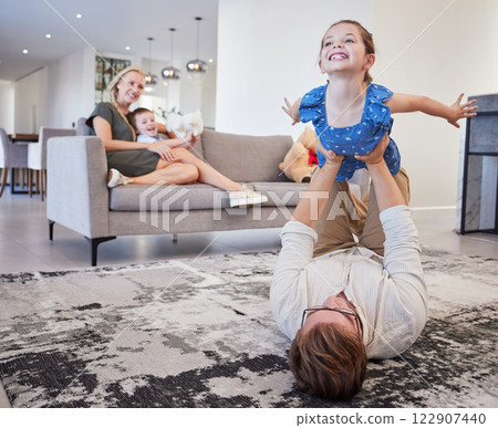 Dad, play and girl in the living room with boy and mom on the sofa in the living room. Trust, love and support as happy child having fun, laugh and joy with her family in home lounge together 122907440
