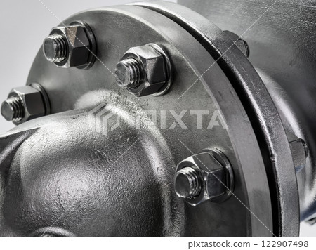 Close-up view of a steel flange with nuts and bolts showcasing industrial engineering precision 122907498