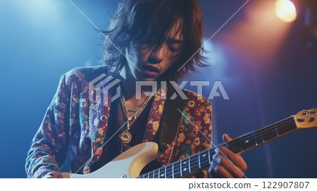 Male musician playing electric guitar on stage 122907807