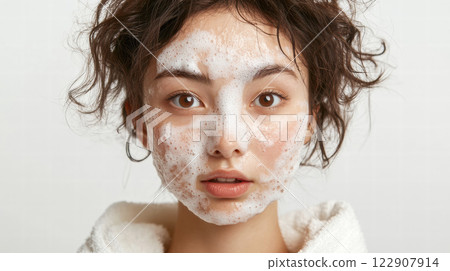A woman applying cleansing foam to her face 122907914