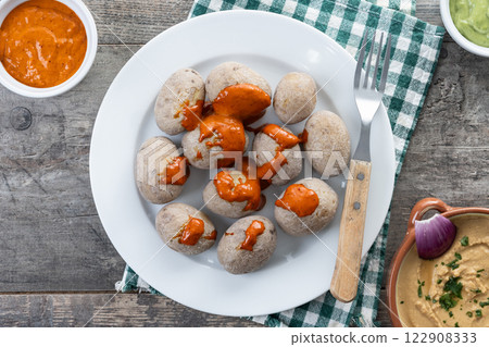 Papas arrugadas with mojo and gofio escaldado on wooden table. Traditional Canary Islands food. 122908333
