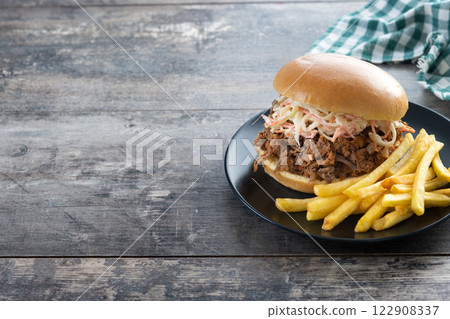 Pulled pork sandwich with coleslaw salad on wooden table Pulled pork sandwich with coleslaw salad on wooden table 122908337