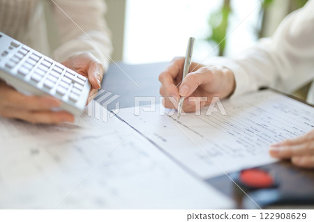 The hands of two women signing a real estate contract 122908629