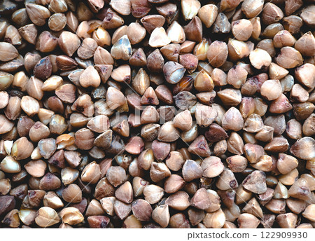 Close-up of raw buckwheat grains, showcasing their natural texture and earthy tones. 122909930
