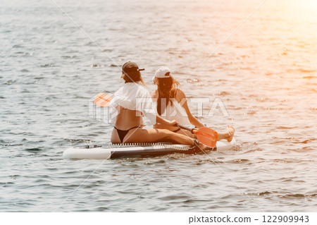 Women Paddleboard Beach Sunset Fun Women Paddleboard Beach Sunset Fun 122909943