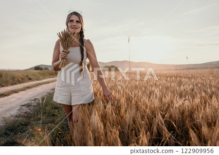 Woman Walking Through a Field of Wheat Woman Walking Through a Field of Wheat 122909956