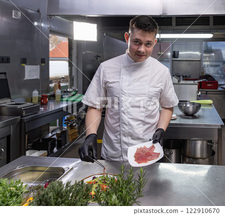 Young chef adding smoked salmon 122910670