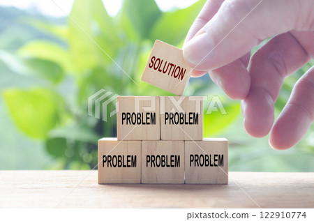 Hand putting Solution wooden cube on top of other problematic cubes. Business solution concept Hand putting Solution wooden cube on top of other problematic cubes. Business solution concept 122910774