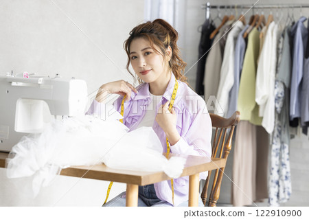 Cute woman using a sewing machine 122910900