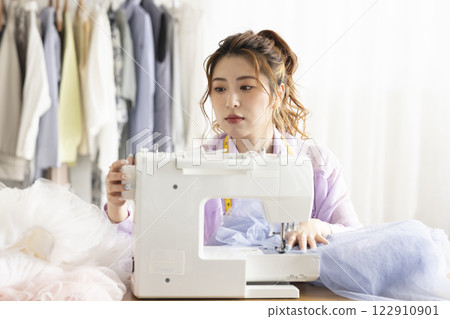 使用縫紉機的可愛女人 122910901
