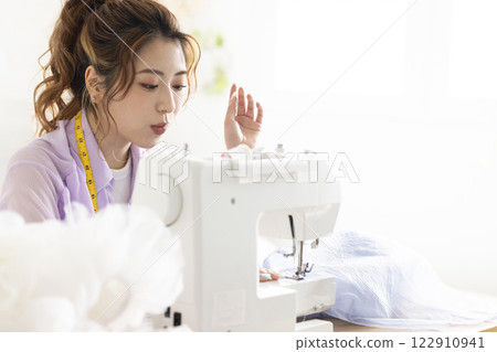 Cute woman using a sewing machine 122910941