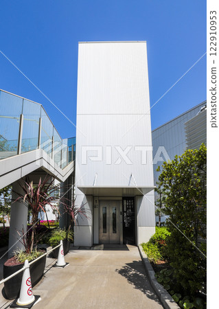 An outdoor elevator going up and down between the 1st floor parking lot and the 2nd floor corridor at Haneda Innovation City 122910953