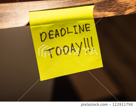 Bright sticky note with a reminder about the deadline today, placed on a desk 122911798