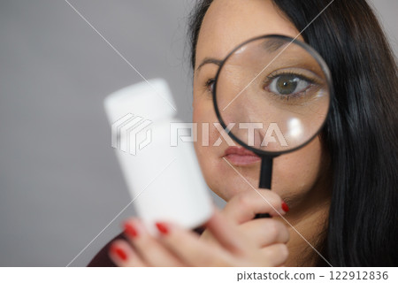 Woman investigating ingredients of medicines Woman investigating ingredients of medicines 122912836