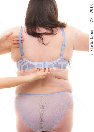 Bra fitter help plus size woman find perfect fit. Back view. 122912918