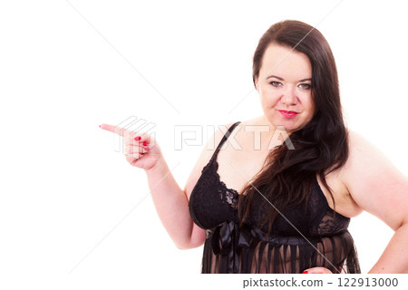Woman plus size in lingerie pointing at copy space 122913000