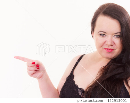 Woman plus size in lingerie pointing at copy space Woman plus size in lingerie pointing at copy space 122913001