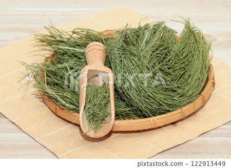 Equisetum arvense, the field horsetail or common horsetail, dried in the basket on wooden table. Equisetum arvense, the field horsetail or common horsetail, dried in the basket on wooden table. 122913449