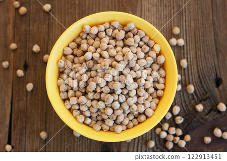 Raw chick peas in an yellow plastic bowl, flat lay. Raw chick peas in an yellow plastic bowl, flat lay. 122913451