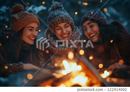 Three happy friends warming up around bonfire during winter holidays 122914002