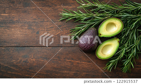 Fresh avocados with rosemary on a rustic wooden table background. Fresh avocados with rosemary on a rustic wooden table background. 122915537