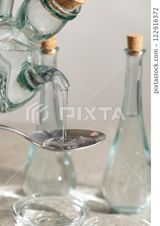 White distilled vinegar is poured into spoon White distilled vinegar is poured into spoon 122916372