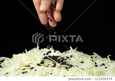 Sprinkling black peppercorns on chopped white cabbage Sprinkling black peppercorns on chopped white cabbage 122916374
