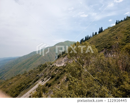 Beautiful landscape in the mountains. Mountains are covered with vegetation. Clouds float in the sky. Beautiful landscape in the mountains. Mountains are covered with vegetation. Clouds float in the sky. 122916445