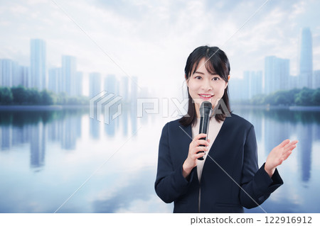A young woman giving a speech using a microphone on a street corner A young woman giving a speech using a microphone on a street corner 122916912