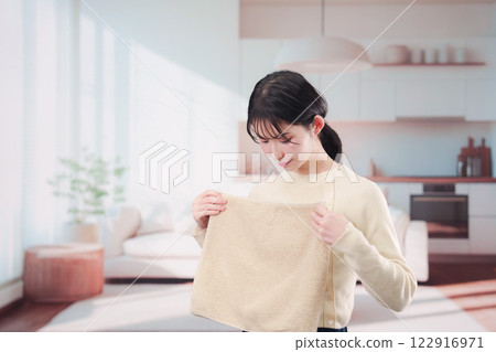 Young woman folding laundry at home Young woman folding laundry at home 122916971