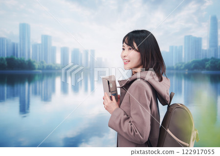 A young woman wearing a coat and walking outside while using a smartphone A young woman wearing a coat and walking outside while using a smartphone 122917055