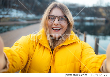 Woman photographer with big backpack taking photo of mountains and blue lake. Travel and hobby concept Woman photographer with big backpack taking photo of mountains and blue lake. Travel and hobby concept 122917177