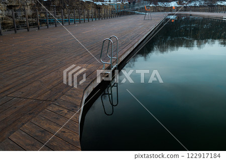 Pool ladder on a cottage wooden pier in a lake Zakrzowek lake, Krakow, Poland. 122917184