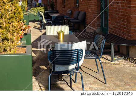 Outdoor street cafe tables ready for service. Empty cafe terrace with table and plastic chair, morning time. Food concept 122917346