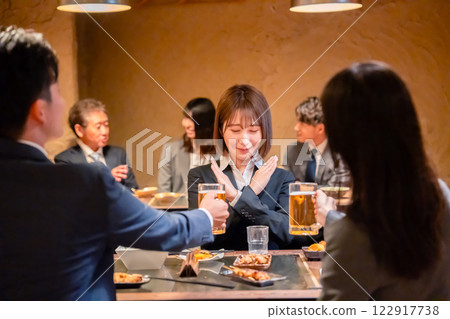 A female employee refuses alcohol offered to her by a senior employee at an izakaya A female employee refuses alcohol offered to her by a senior employee at an izakaya 122917738