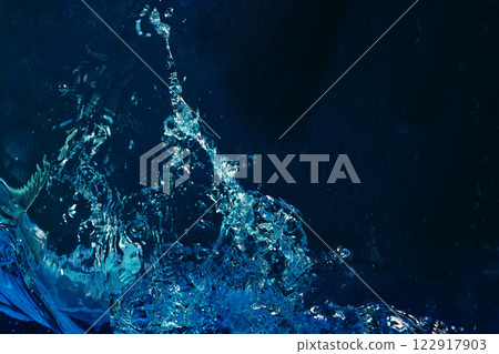Water splashes on a dark blue background Water splashes on a dark blue background 122917903