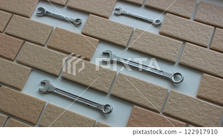Shiny Chrome Spanners Arranged Inside Separate Compartments In Brickwork Shiny Chrome Spanners Arranged Inside Separate Compartments In Brickwork 122917910
