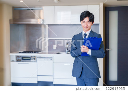 一家房地產公司的男工作人員正在展示一套二手房 122917935