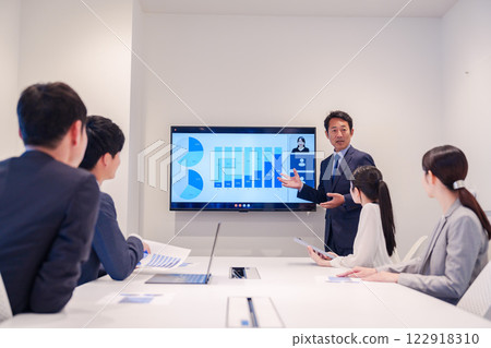 一位中年上班族在會議上一邊看資料一邊做演講 122918310