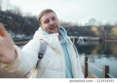 Young happy man takes selfie photo during his awesome hiking trek somewhere in forest, walking by the lake Young happy man takes selfie photo during his awesome hiking trek somewhere in forest, walking by the lake 122918391