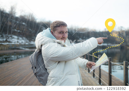 Male hiker wearing backpack reading map during near a lake through forest, discovering scenic wilderness trail with peaceful landscape Male hiker wearing backpack reading map during near a lake through forest, discovering scenic wilderness trail with peaceful landscape 122918392