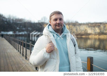 Happy bearded young man standing and smiling in wintertime outdoors Happy bearded young man standing and smiling in wintertime outdoors 122918393