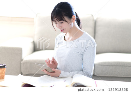 A young woman studying alone in the living room A young woman studying alone in the living room 122918868