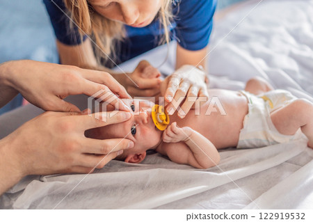 A newborn baby receives gentle osteopathic care, lying calmly while the specialist carefully examines and adjusts the infant. A moment of professional pediatric care, early development, and holistic A newborn baby receives gentle osteopathic care, lying calmly while the specialist carefully examines and adjusts the infant. A moment of professional pediatric care, early development, and holistic 122919532