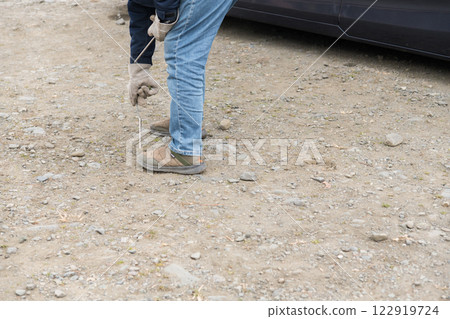 [Auto camping on the Nakatsugawa riverbed, removing the guy rope pegs and withdrawing] 122919724