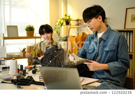 Two fashion designers collaborating on custom denim project in a stylish studio Two fashion designers collaborating on custom denim project in a stylish studio 122920236