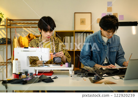 Creative fashion designers working on new designs in a stylish workspace 122920239