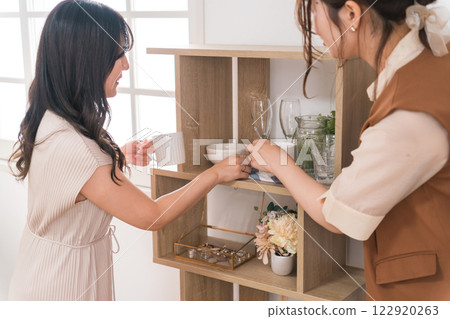 一位女士喜歡在雜貨店、室內裝飾店和服裝店購物。 122920263