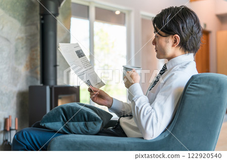 早上，穿著西裝的亞洲商人在家看英文報紙 122920540