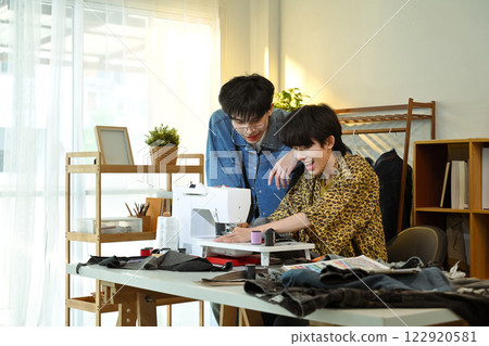 Happy designers working on a new clothing project in a bright fashion studio Happy designers working on a new clothing project in a bright fashion studio 122920581